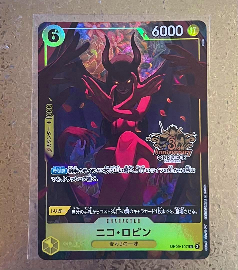 Front of a One Piece trading card (ニコ・ロビン OP09-107) showing holographic artwork in a clear protective sleeve.