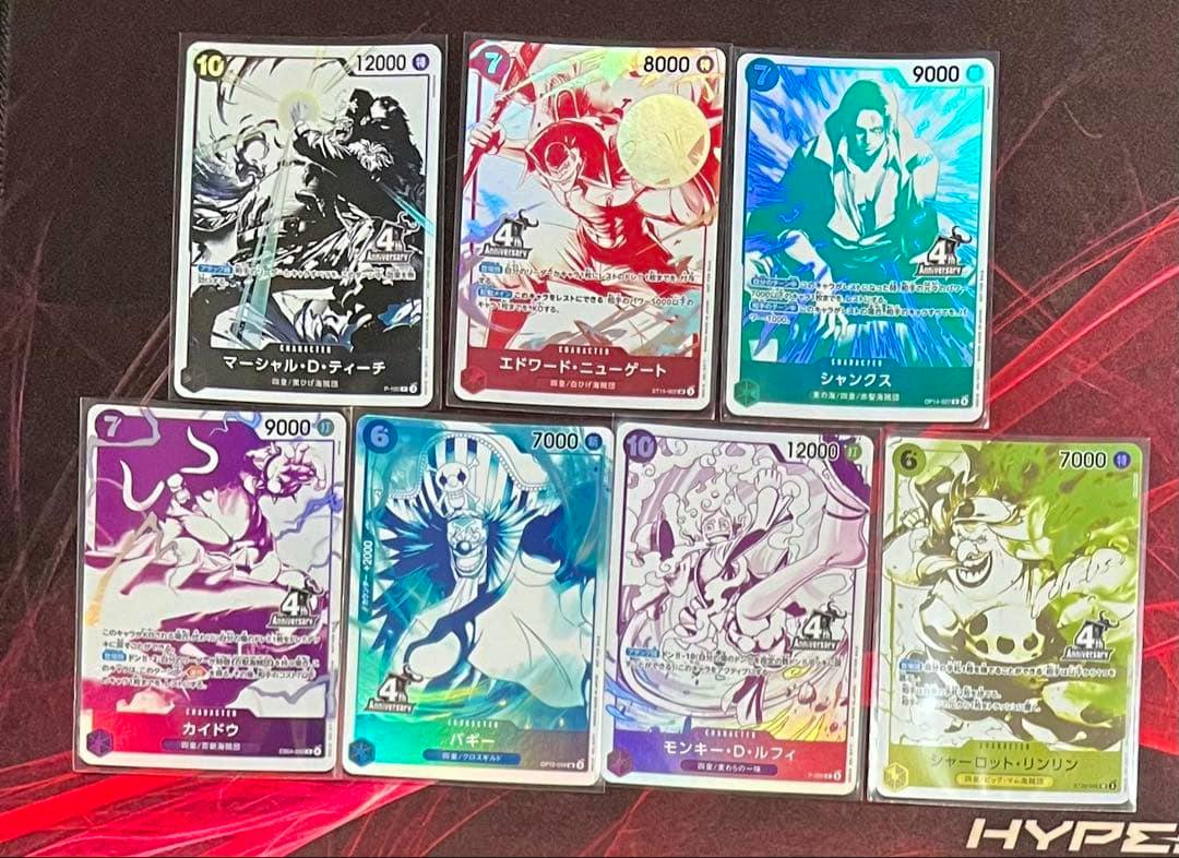 Seven One Piece trading card promo fronts showing character artwork and card text arranged on a surface.