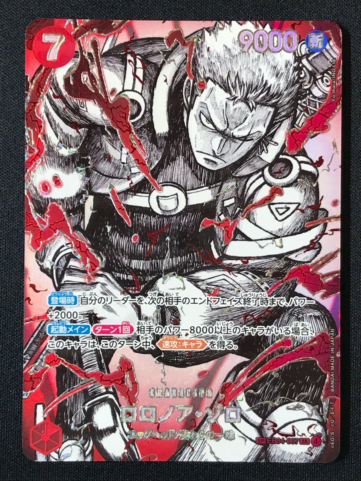 Close-up photo of the One Piece trading card showing Roronoa Zoro artwork with red foil highlights and Japanese text.