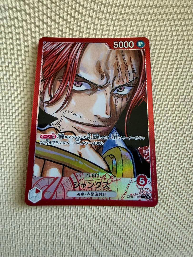 Front of the One Piece trading card showing Shanks artwork, stats, and Japanese card text.