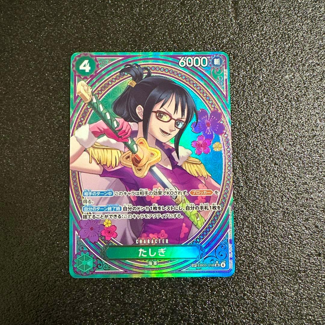 Front of the One Piece trading card たしぎ (EB03-018) showing the character Tashigi holding a sword on a holographic background.