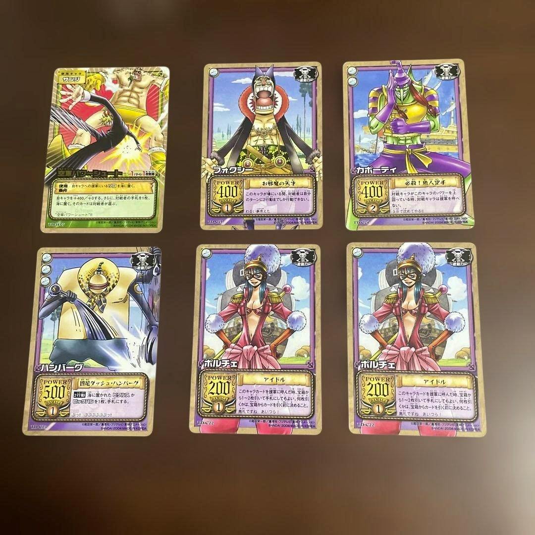 Front faces of six One Piece Carddass trading cards featuring Foxy Pirates characters arranged in two rows on a brown surface.