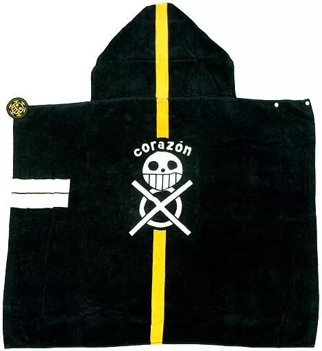 Black hooded hand towel with a yellow vertical stripe and a white "corazón" skull-and-crossbones logo.