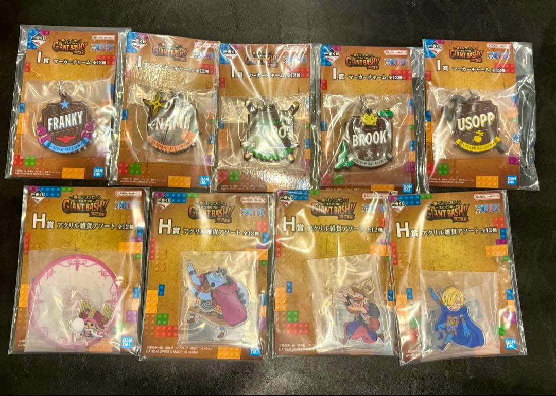 Packaged One Piece GIANT BASH acrylic decorative stands and charms from Ichiban Kuji displayed on a dark surface.