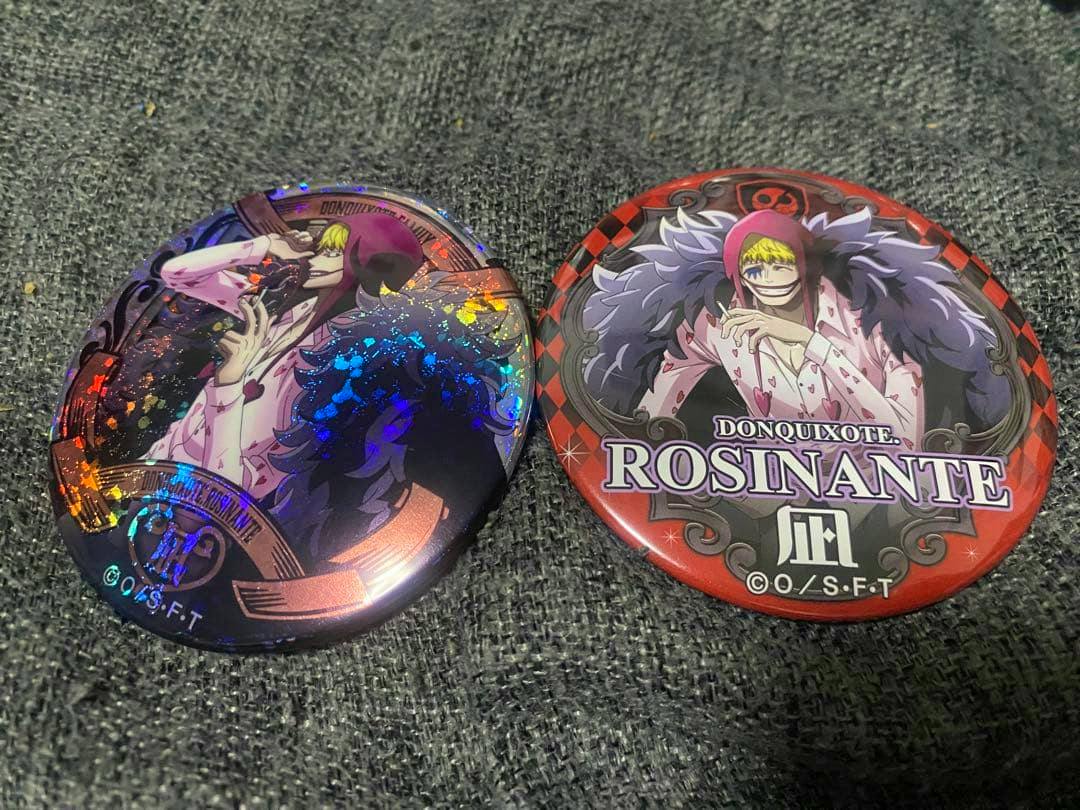 Two round can-style badges of the One Piece character Rosinante shown on a gray fabric background.