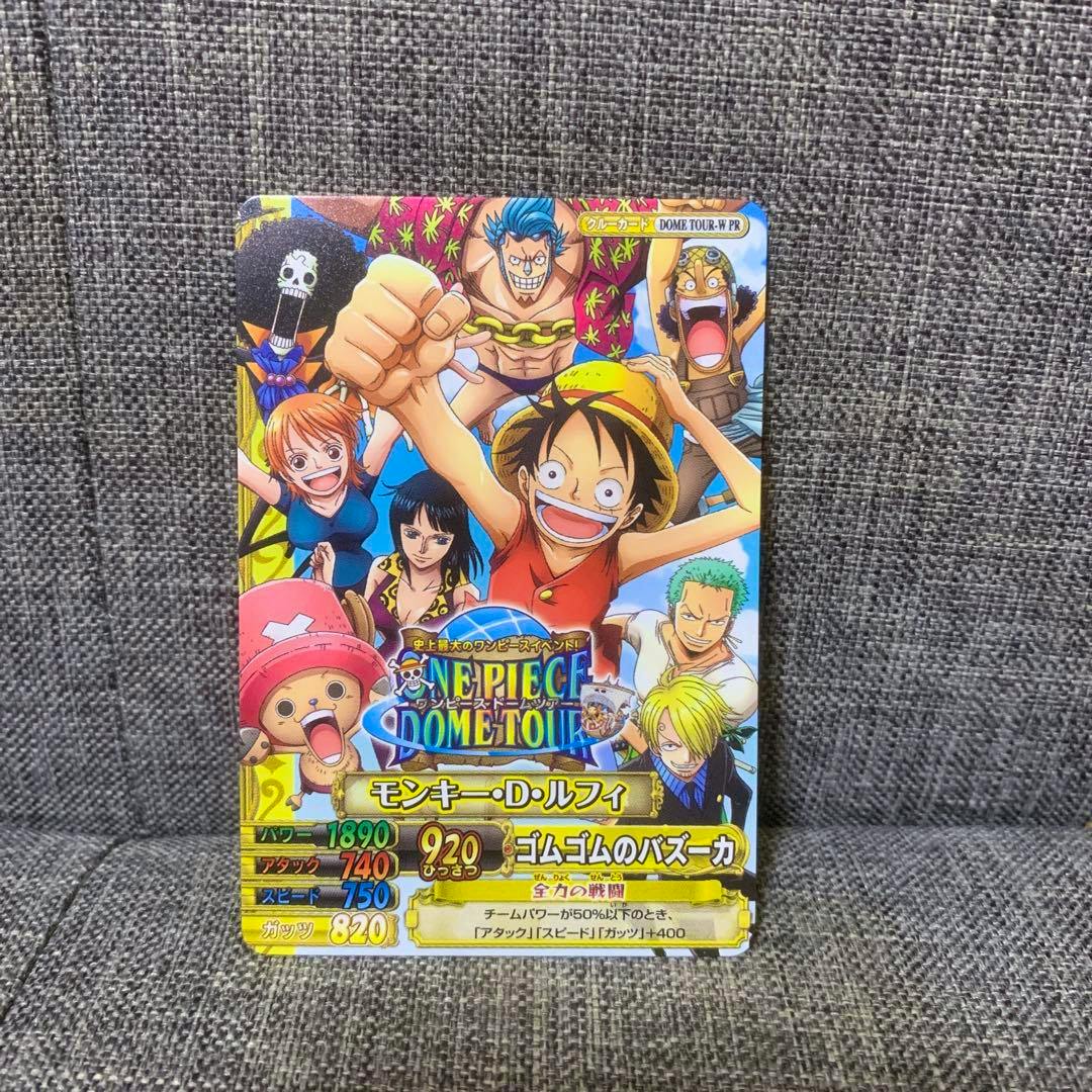 Front of the ONE PIECE toy paper card showing Monkey D. Luffy and other characters with printed game stats and logos.