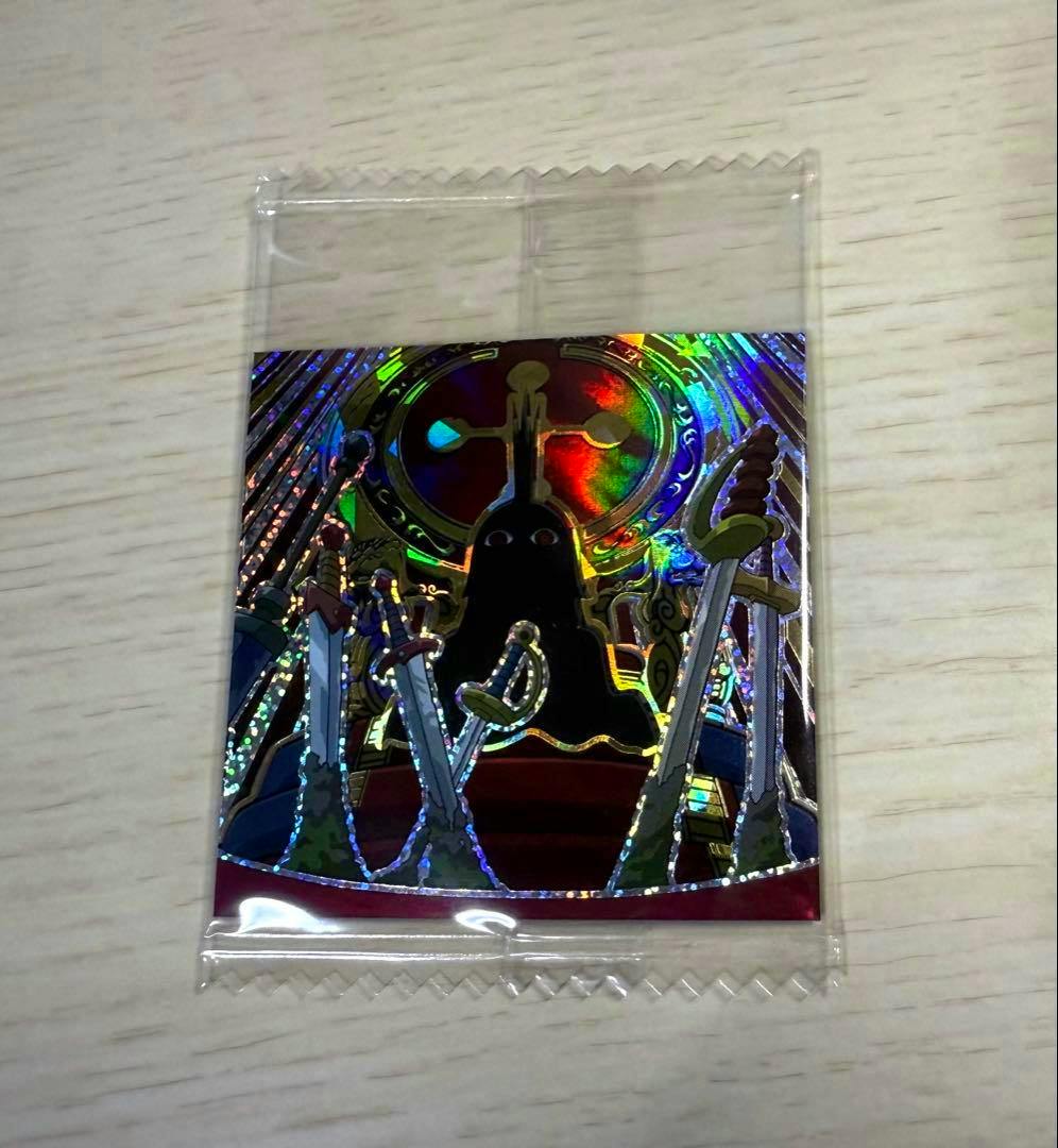 Sealed holographic paper sticker in a clear plastic sleeve showing a dark figure on a throne with surrounding swords.