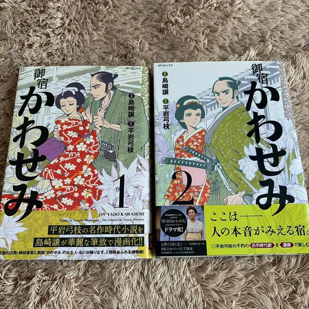 Front covers of the comic book set 御宿かわせみ volumes 1 and 2 shown side by side on a textured surface.