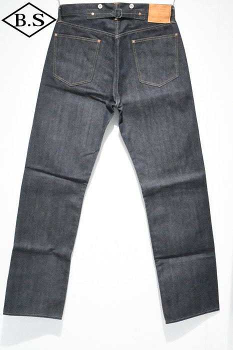 Back view of non-wash blue denim OOE YOFUKUTEN jeans laid flat showing rear pockets and a leather waistband patch.