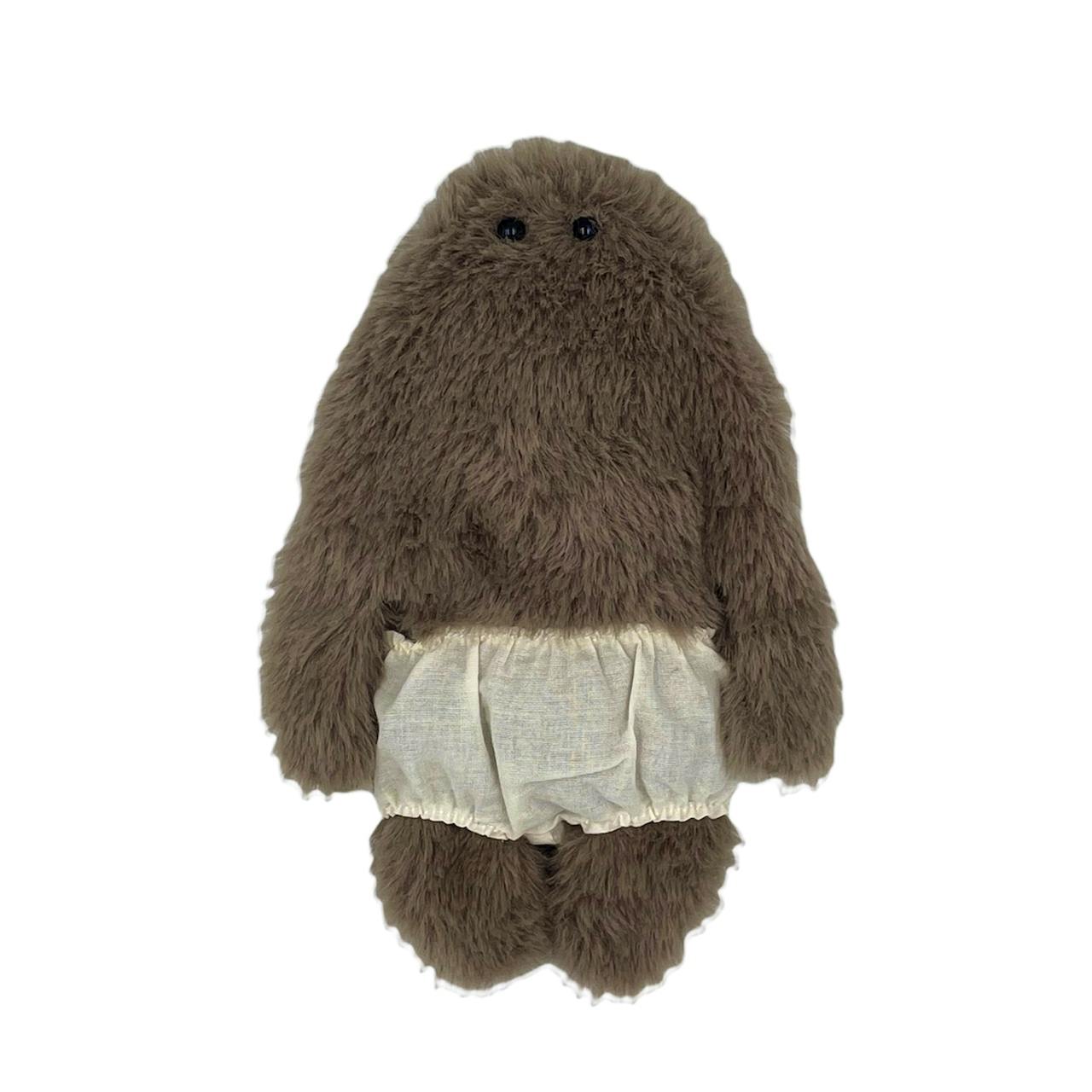 Front view of a brown furry plush pouch wearing white cloth underpants with two small black eyes.