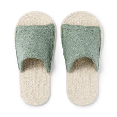 Top-down view of a pair of front-open room slippers with cream-colored soles and green fabric uppers.