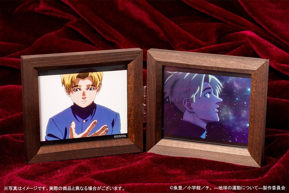Two wooden-framed music boxes showing anime character illustrations displayed on a red velvet background.