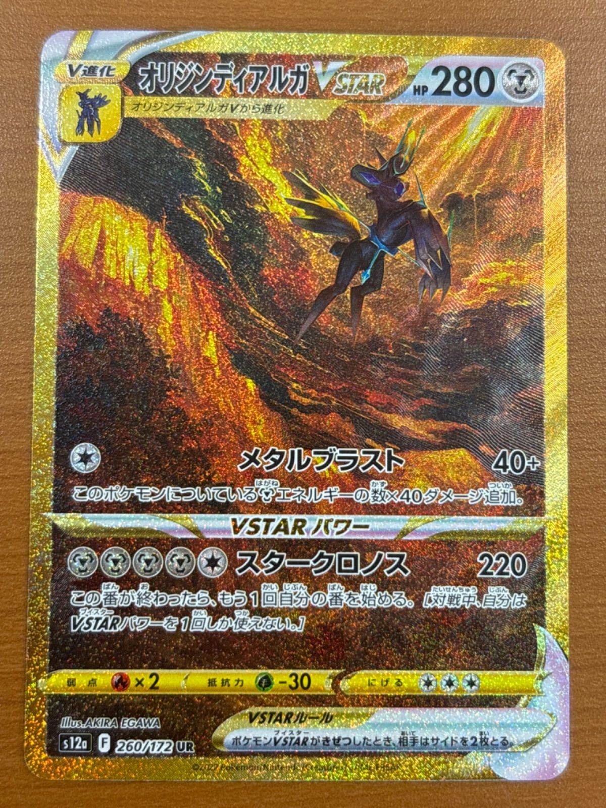 Photo of the trading card 'オリジンディアルガ VSTAR' showing the holographic card face and Japanese text.