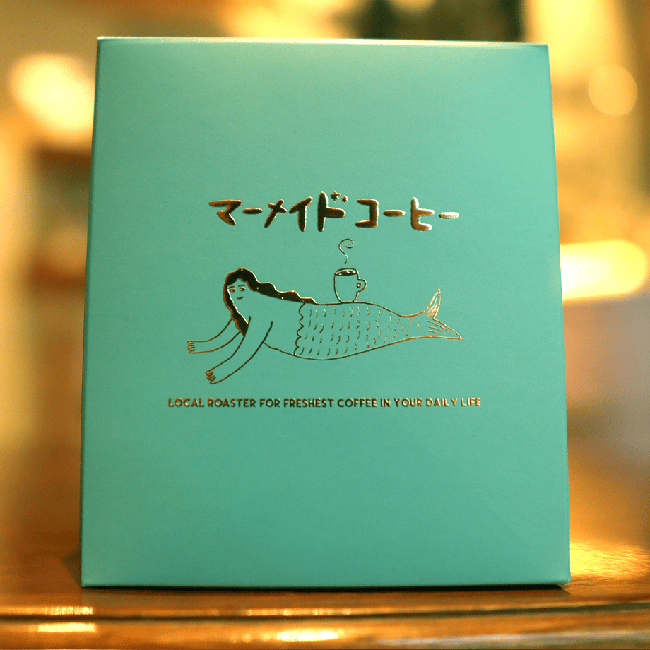 Turquoise coffee box with a mermaid illustration and Japanese product text on the front.