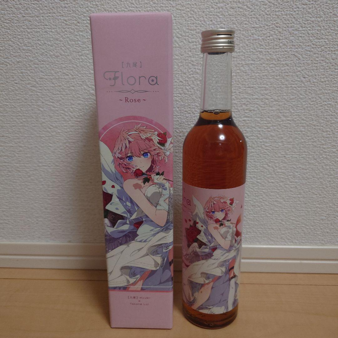 A bottle of liqueur with a pink illustrated label standing next to its matching pink box showing the collaboration character artwork.