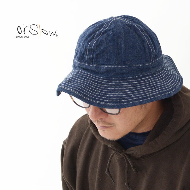 Model wearing a dark denim US Navy hat with visible white topstitching.