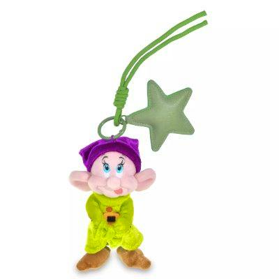 Plush keychain showing a small purple-hatted, yellow-clothed character with brown shoes attached to a green star charm and green strap.
