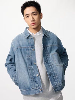 A man modeling an oversized light-blue denim jacket.