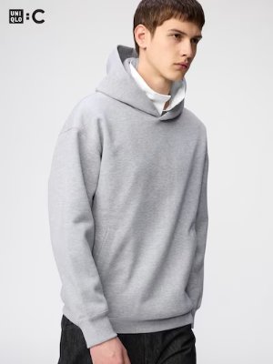 Model wearing a grey oversized pullover hoodie sweatshirt.