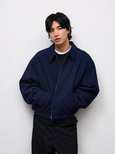 Male model wearing a navy oversized men's jacket zipped in front against a white background.