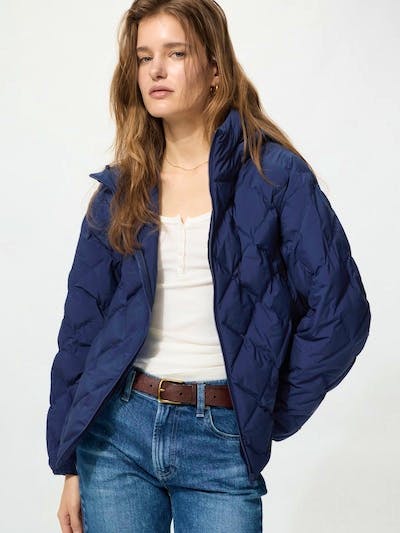 Model wearing a navy padded utility short jacket over a white top and jeans.