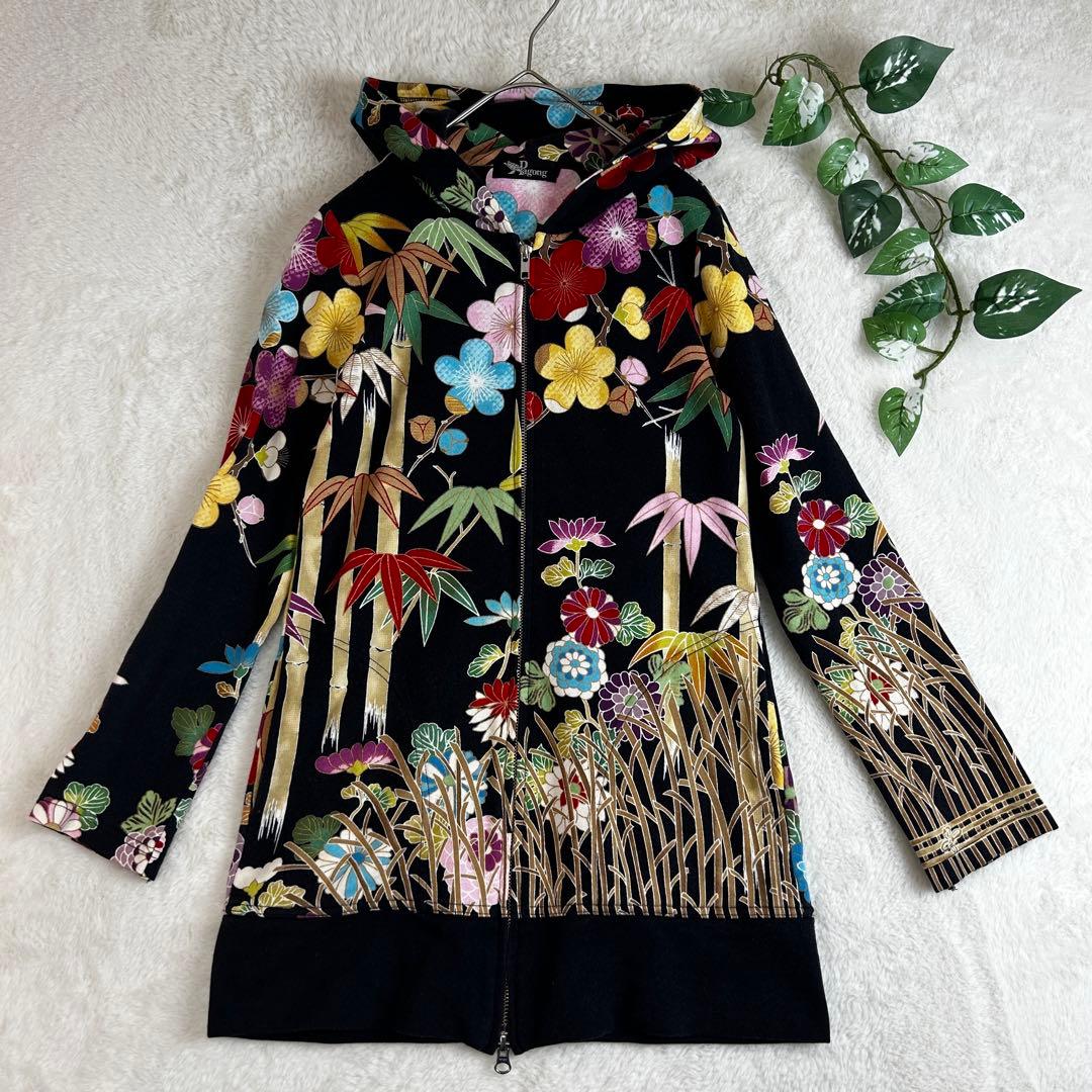 Black Pagong double-zip women's cotton parka with all-over plum and bamboo floral pattern laid flat on a white background.