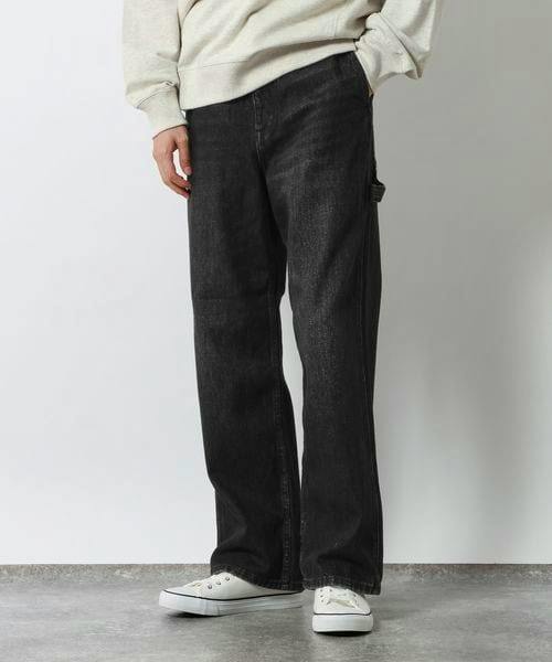 Model wearing black painter-style women's denim jeans shown full-length from the front.