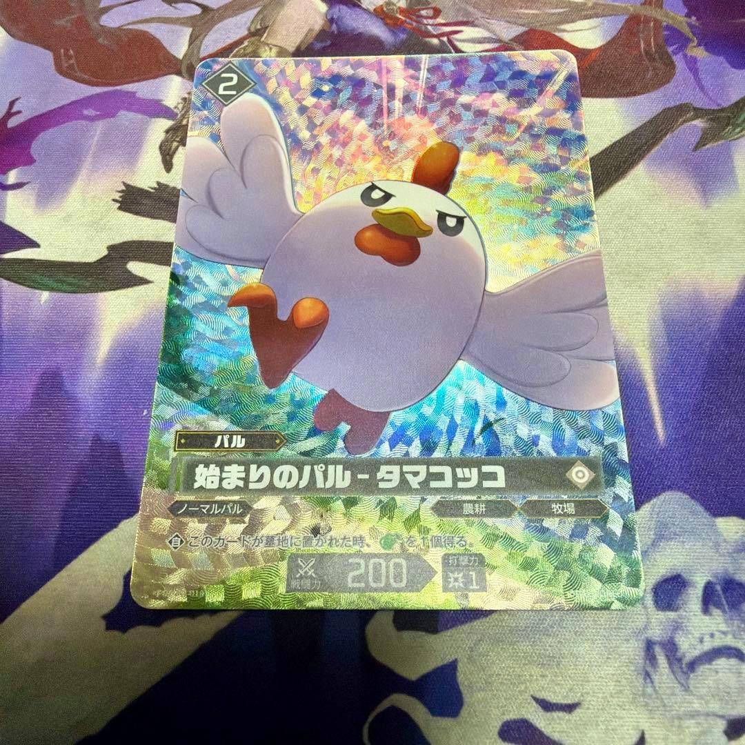 A holographic trading card showing 始まりのパル - タマコッコ placed on a playmat.