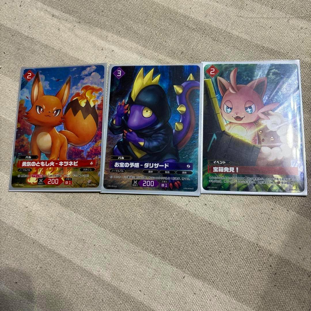 Three promotional trading cards from the listing laid flat on fabric, each showing illustrated characters and artwork described in the product title.