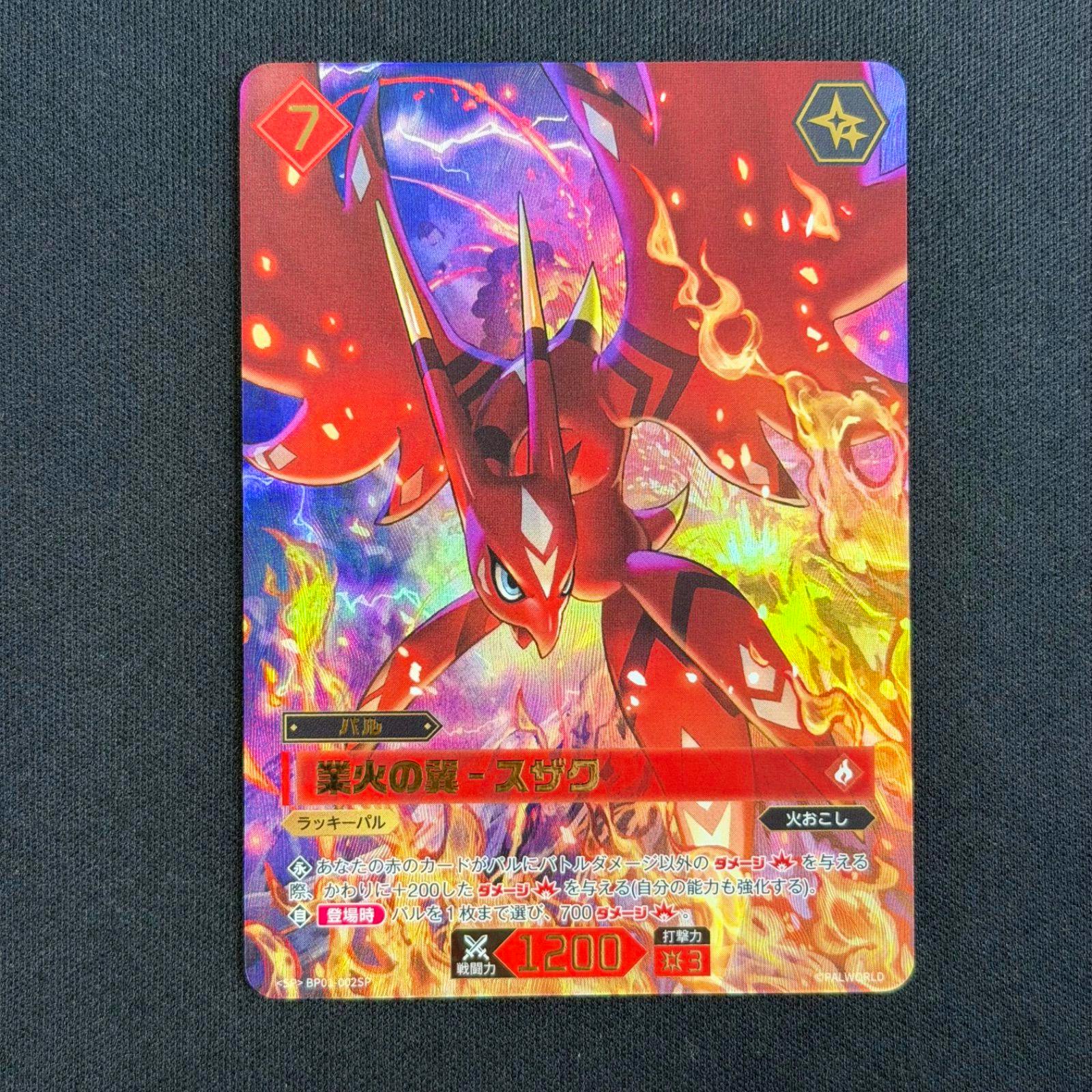 Photograph of the front of the Parworld trading card “業火の翼-スザク” showing a red creature and Japanese text on a dark fabric background.