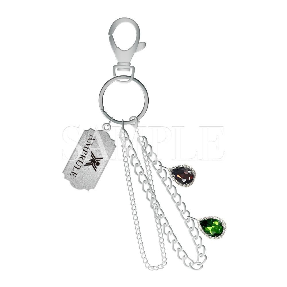 Metal keychain charm with a lobster clasp and split ring, three hanging chains, a rectangular tag, and two teardrop gem charms on a black background.