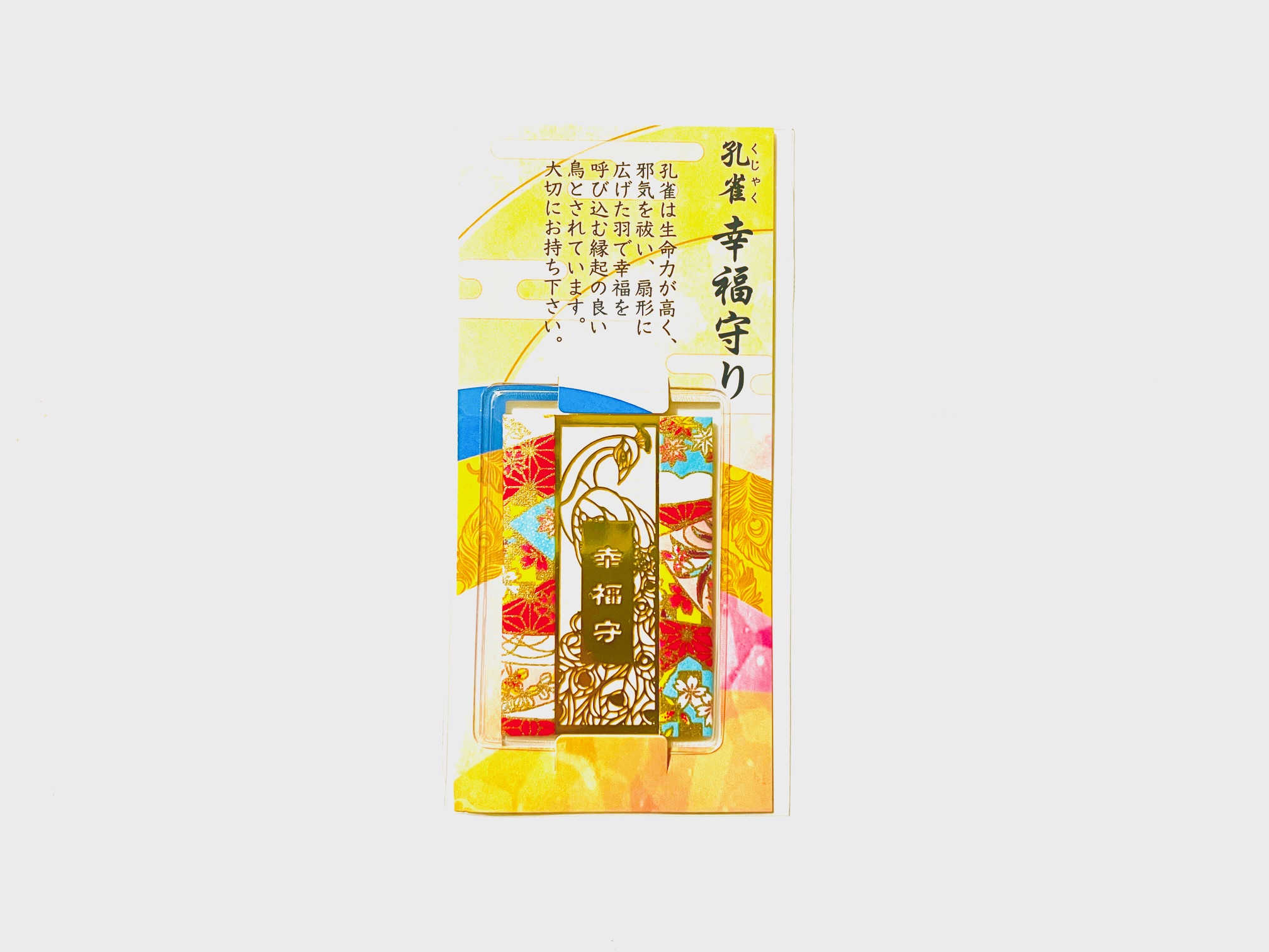 A metal rectangular bookmark with a peacock design displayed on colorful backing card packaging.