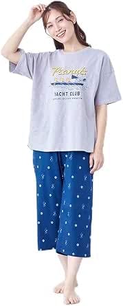 Woman wearing a Peanuts women's pajama set with a light gray short-sleeve top and blue patterned cropped pajama pants.