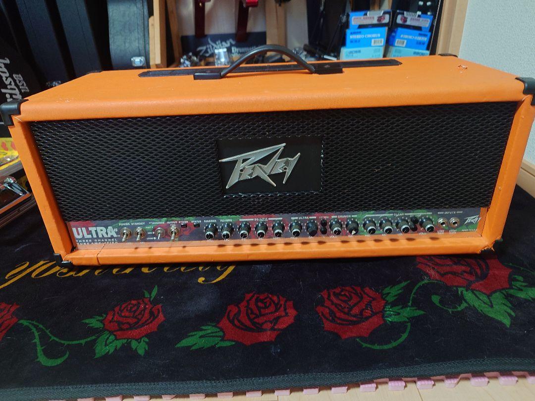 Front view of an orange Peavey ULTRA plus tube amplifier head showing the grille, Peavey logo, and front control panel.