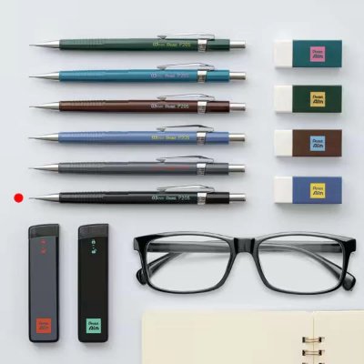 Several mechanical pencils, rectangular erasers, glasses, and other stationery items arranged on a gray background.
