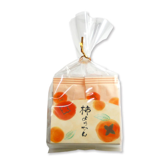 Clear cellophane bag containing individually wrapped persimmon yokan pieces with illustrated persimmon-patterned wrappers.