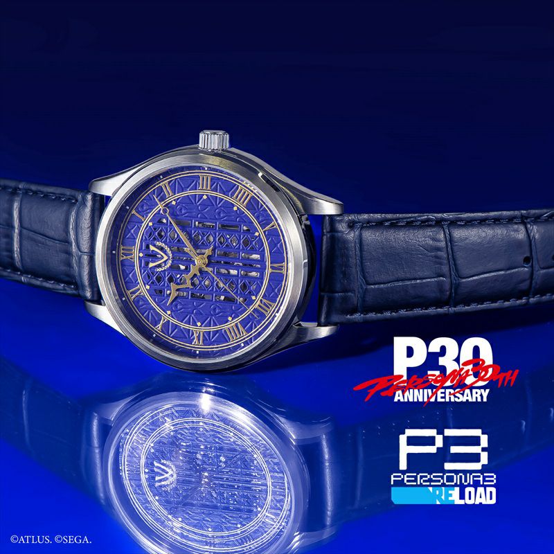 Metal-cased wristwatch with a blue patterned dial and blue leather strap displayed on a blue background with Persona 3 Reload logos.