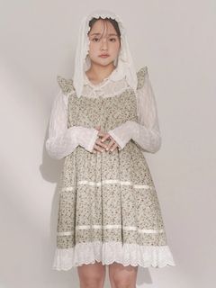 Model wearing the petit flower flare mini one-piece (women's cotton dress) in a small floral print layered over a white long-sleeve blouse and a white headscarf.