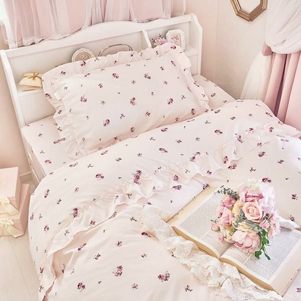 Semi-double pink duvet cover three-piece set with small rose print and ruffled edges displayed on a bed.