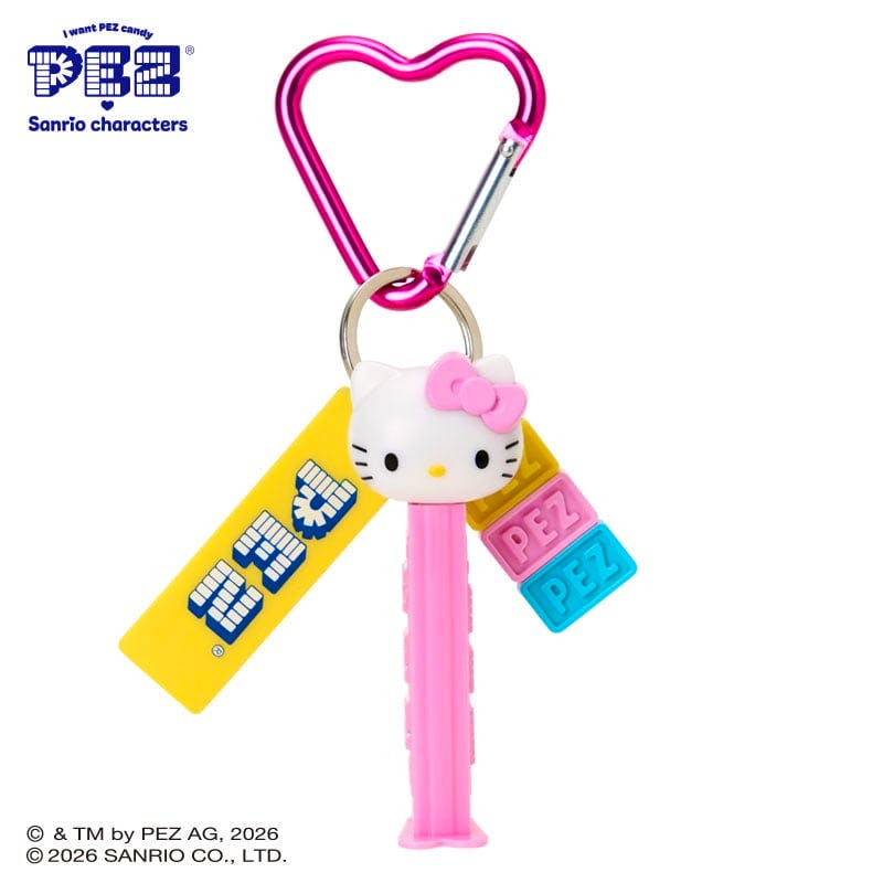 Pink PEZ plastic keychain featuring a white cat character PEZ dispenser head, a yellow PEZ tag, three colorful PEZ block charms, and a pink heart-shaped carabiner.