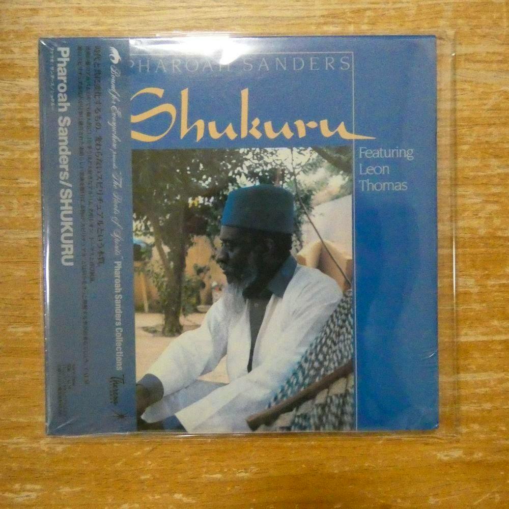 Sealed front cover of the CD 'Shukuru' by Pharoah Sanders showing album artwork with a seated man wearing a hat against a blue background.