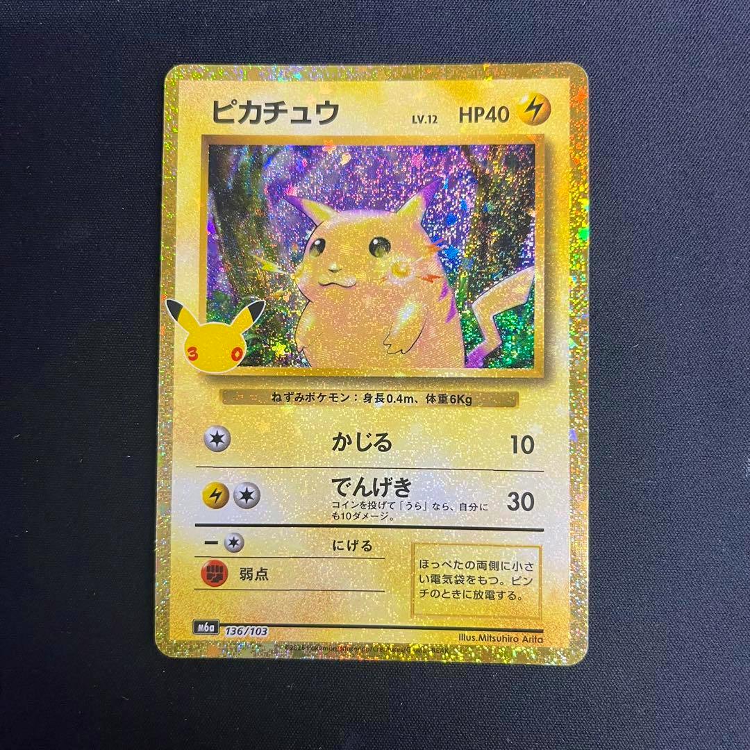 Front of the Pikachu trading card (136/103, 30th anniversary reprint) showing holographic artwork on a dark background.