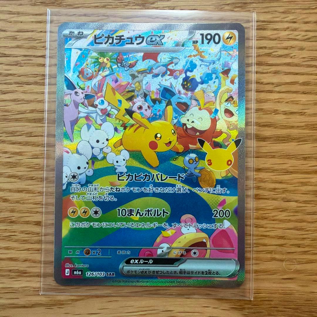 Pikachu ex SAR (126/103) trading card in a clear protective sleeve on a wood surface, showing the full holographic front.
