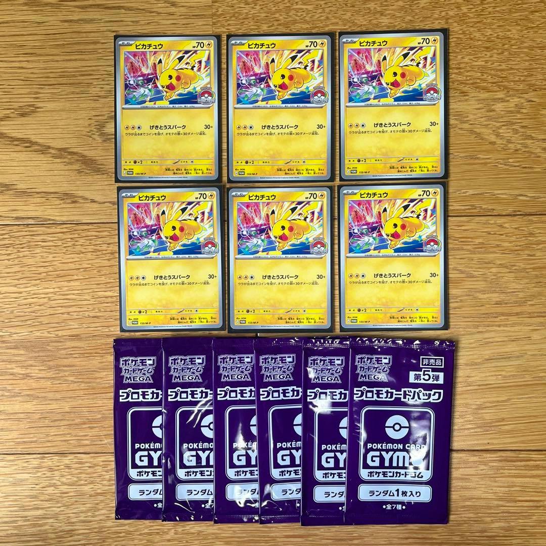 Six Pikachu promo trading cards and six purple Pokémon Gym promo card packs arranged on a wooden surface.