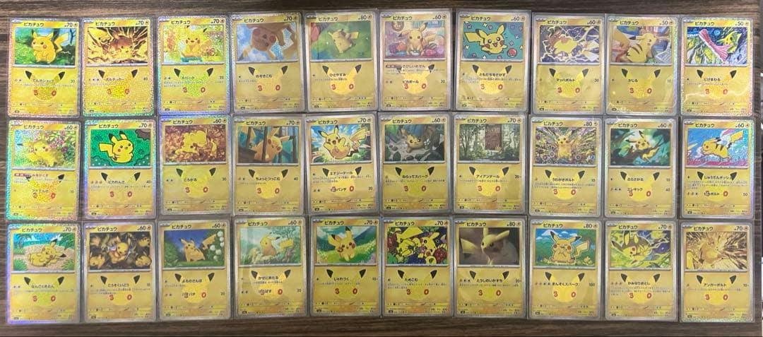 Many Pikachu trading cards from the 30th Celebration set arranged in a grid on a wooden surface.
