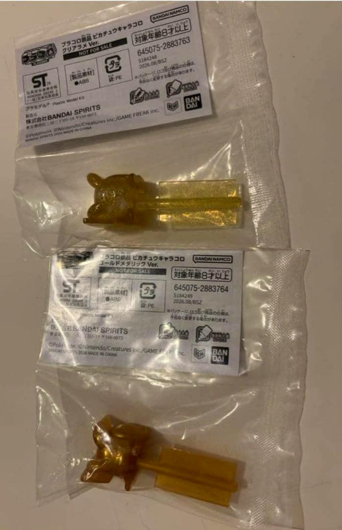 Two gold metallic Pikachu plastic figures in sealed clear bags with visible product labels.