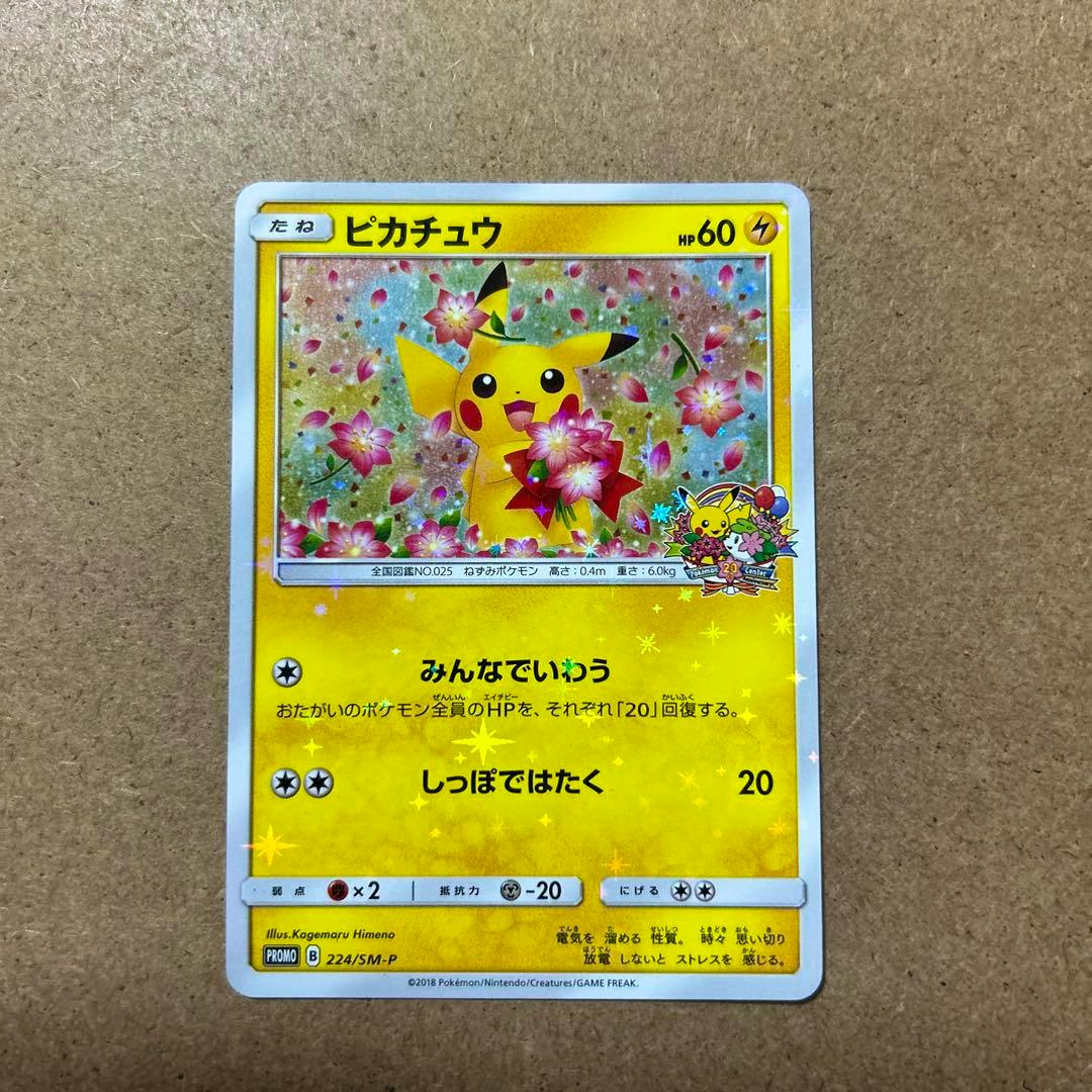 Front of the Pikachu trading card showing Pikachu holding flowers with a floral holographic background and Japanese text.