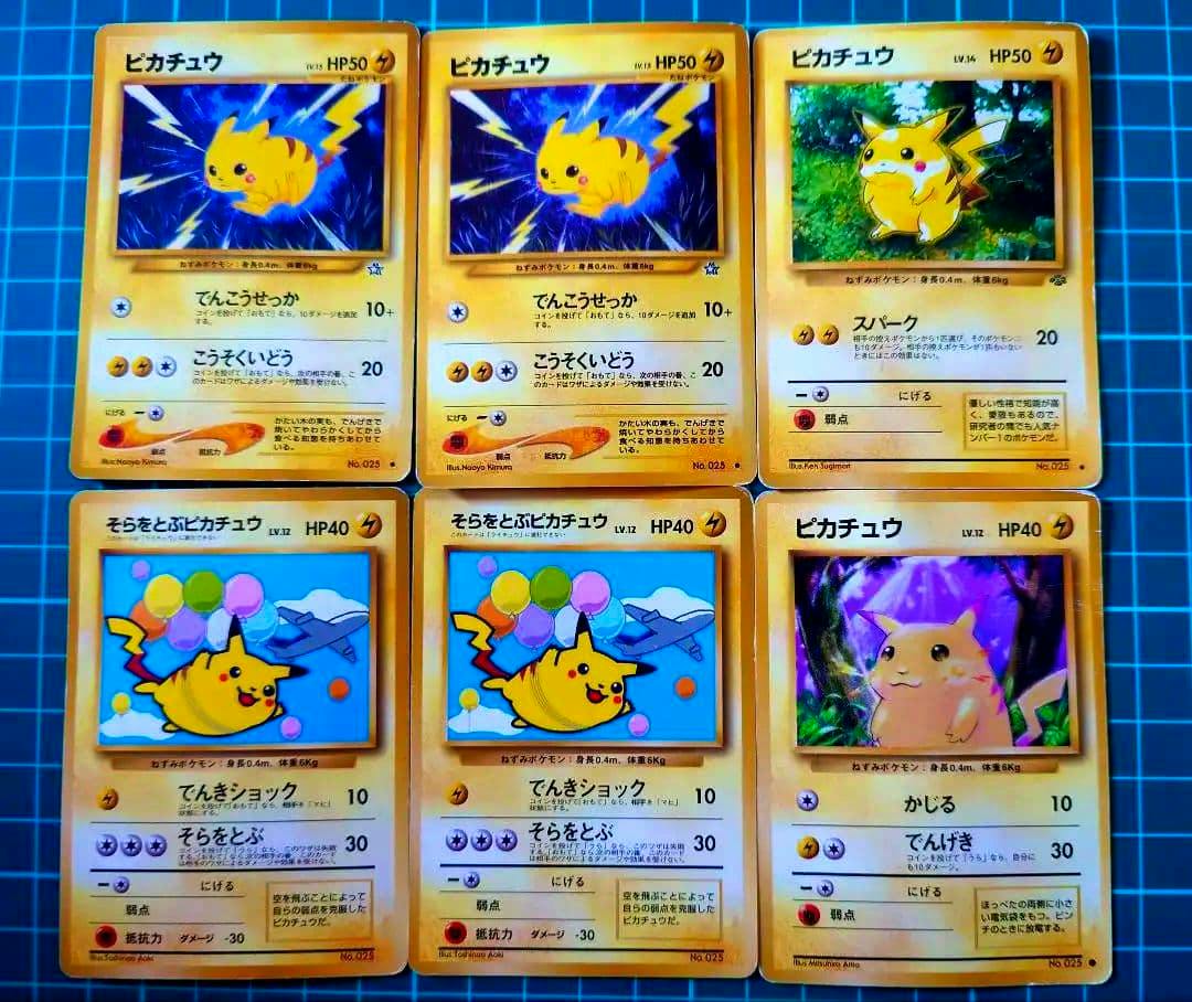 Fronts of six Pikachu Pokémon trading cards arranged in two rows on a gridded mat.