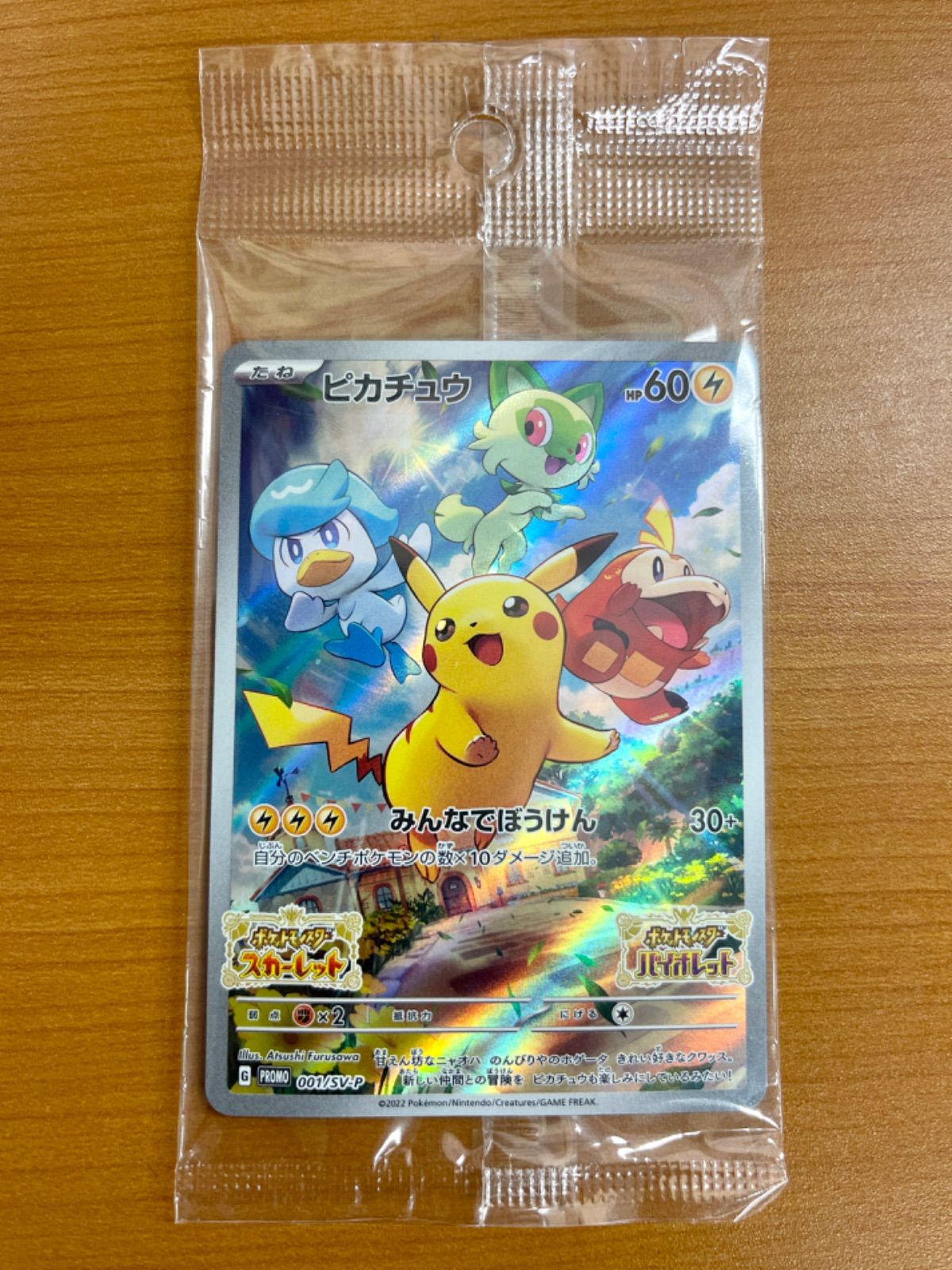 Sealed Pikachu promo trading card (001/SV-P) in a clear plastic sleeve on a wooden surface.