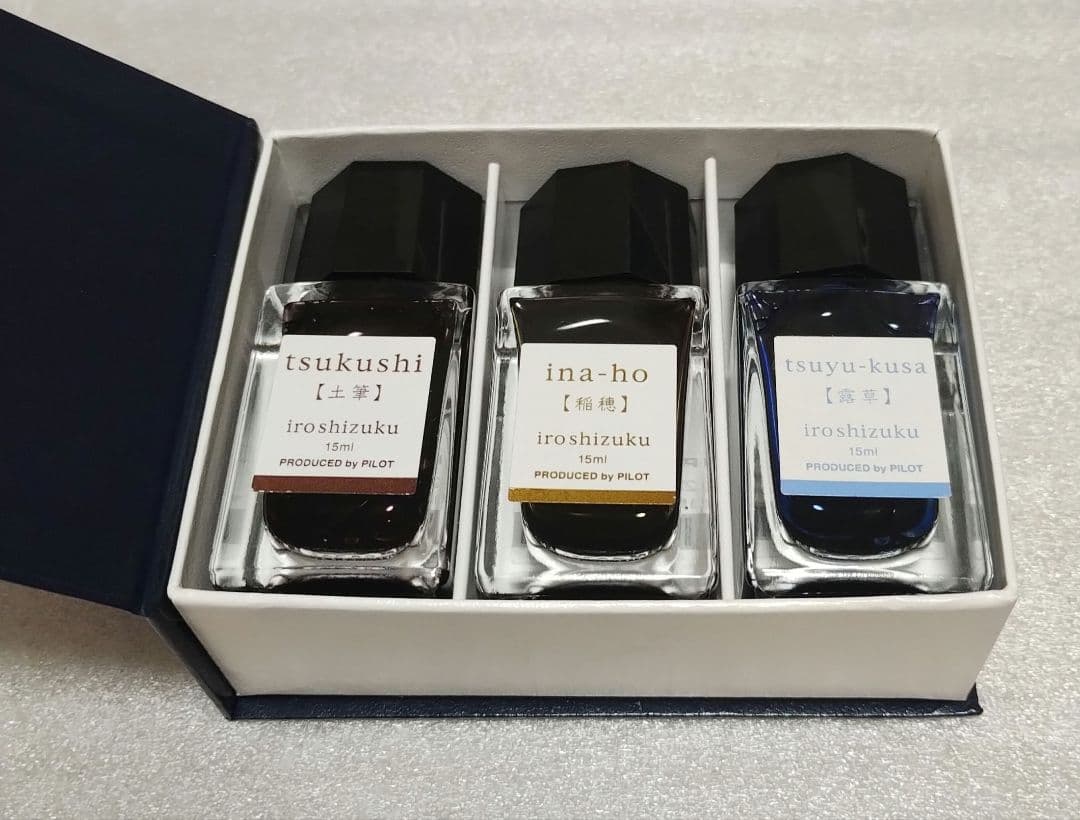 Three Pilot Iroshizuku ink bottles labeled tsukushi, ina-ho, and tsuyu-kusa displayed in a box.